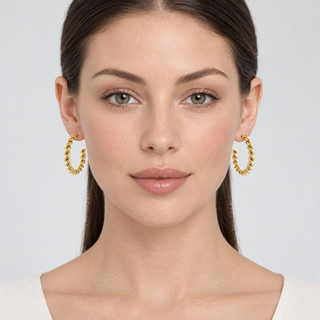 Forward-facing model wearing both Melia gold hoop earrings