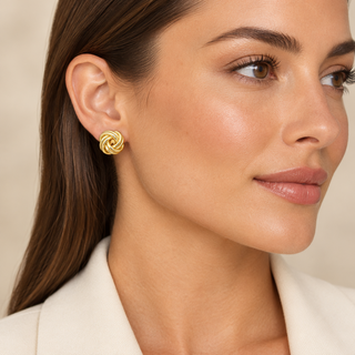 Model wearing Quant gold knot clip-on earrings